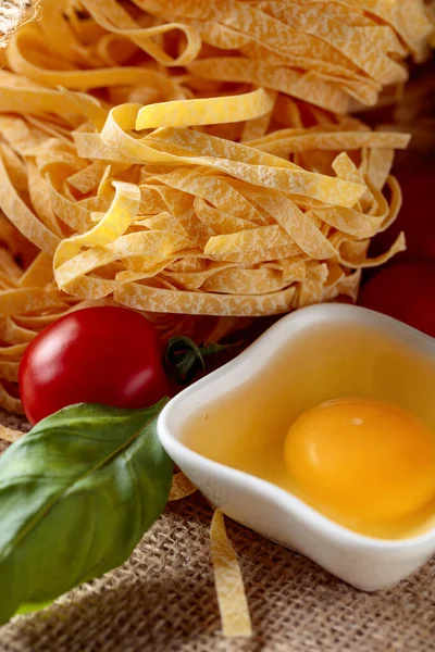 Homemade raw egg noodles with tomato and basil. — Stock Photo, Image