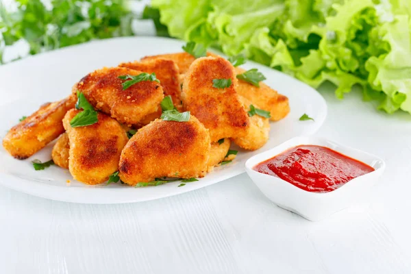 Stekt kyckling nuggets med ketchup beströdd med hackad parsle — Stockfoto