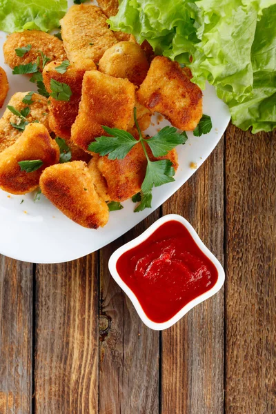 Stekt kyckling nuggets med ketchup beströdd med hackad parsle — Stockfoto