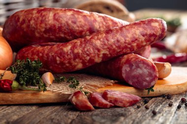 Eski ahşap bir masada ekmek ve baharat ile kuru-tedavi sosis.