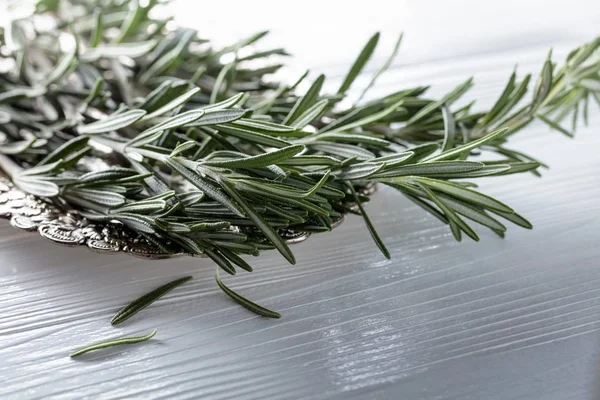 Rosemary on a white wooden table. — Stock Photo, Image