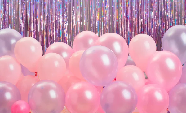 Pink and purple balloons on colorful background.