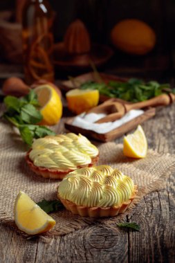 Eski ahşap bir masada limon kremalı ve nane şekerli tart. 