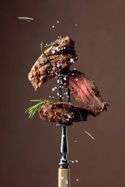 烤牛肉牛排,带有迷迭香,背景为褐色. — 图库照片