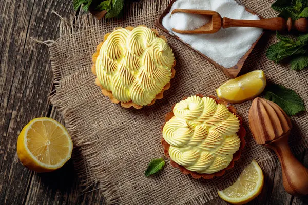 Tartelettes à la crème au citron et menthe sur une vieille table en bois . — Photo