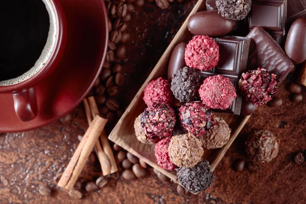 Vários chocolates e xícara de café preto . — Fotografia de Stock