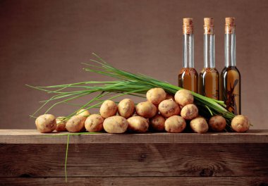 Sebze yağlı taze organik patatesler ve eski ahşap bir masada yeşil soğan. Boşluğu kopyala.