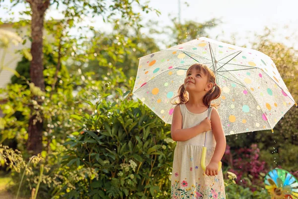 傘を差した少女は空を見ている 夏の雨の下で庭の美しい女の子 村での休暇 — ストック写真