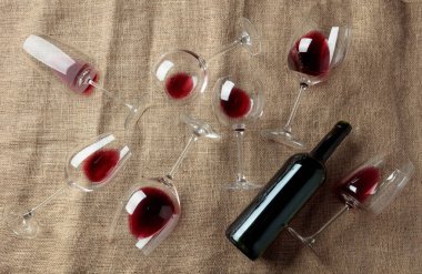 Çuval beziyle kaplı bir masada kırmızı şarap. Üst görünüm.