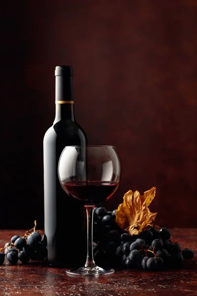 Red wine and grapes on a brown background. Free space for your content.
