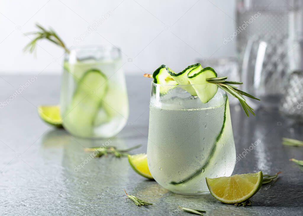 Detox drink or green iced refreshing lemonade with rosemary, cucumber and lime. Cold drink in frosted glass.