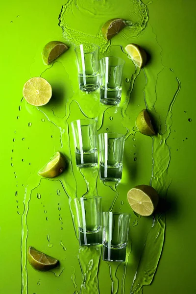 Small Shot Glasses Lime Slices Flowing Drink Green Background — Stock Photo, Image