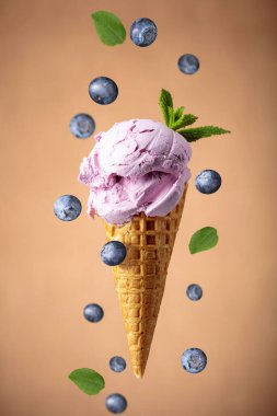 Waffle külahında nane aromalı yabanmersinli dondurma. Kahverengi arka planda dondurma..
