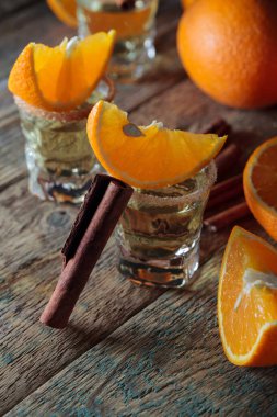 Eski ahşap masada portakal ve tarçınlı tekila. .