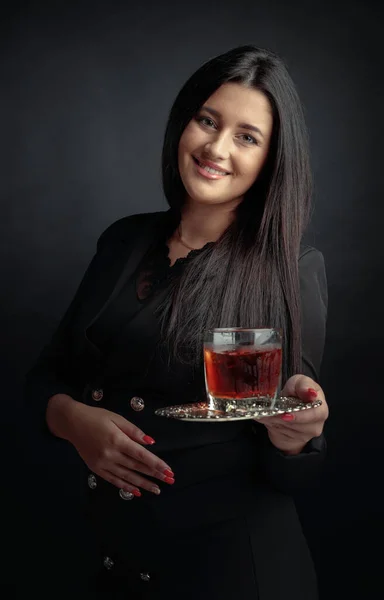 魅力的な女の子は蒸しガラスに氷をウイスキーを提供しています 美しいブルネットで黒でカクテルで冷凍ガラス — ストック写真