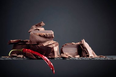 Siyah arka planda kırmızı biberli siyah çikolata. Boşluğu kopyala.