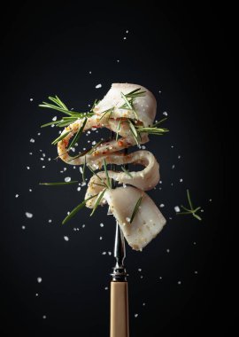 Tuz ve biberiye serpilmiş baharatlı domuz yağı dilimi. Siyah arka planda biberiyeli domuz yağı..