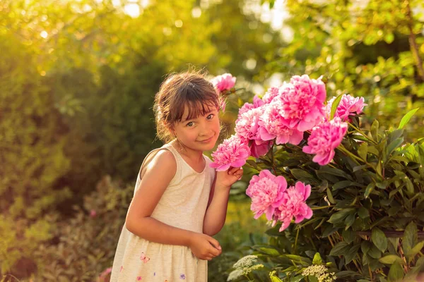 ピンクの牡丹の庭の女の子 庭の夏の夜 — ストック写真