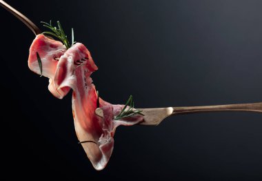 Siyah arka planda domuz pastırması ve biberiye. Boşluğu kopyala.