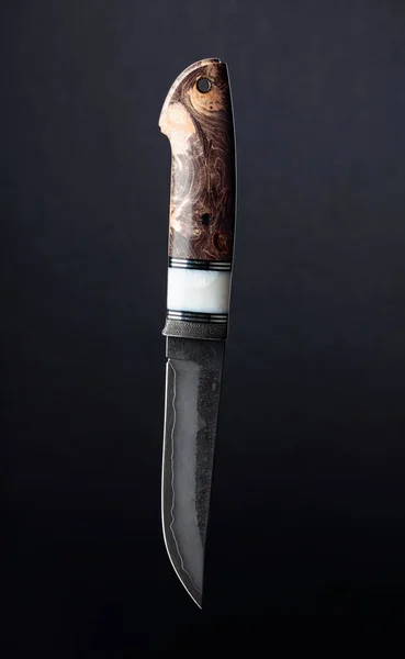 Hunter combat knife on a black background. The surface of the blade - etching, traces of forging. Handle - inlace acrylester, Japanese maple.