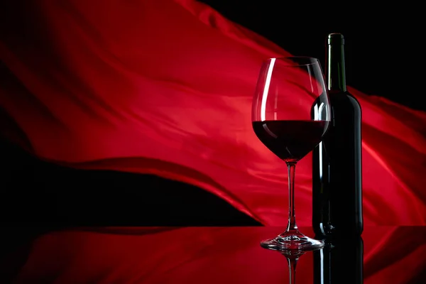 Weinglas Und Flasche Rotwein Auf Schwarzem Reflektierendem Hintergrund Roter Satinvorhang — Stockfoto