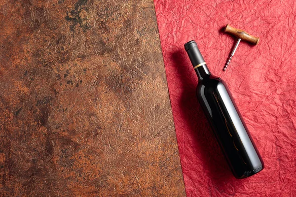 stock image A bottle of red wine on an old rough background. View from above. Copy space. 