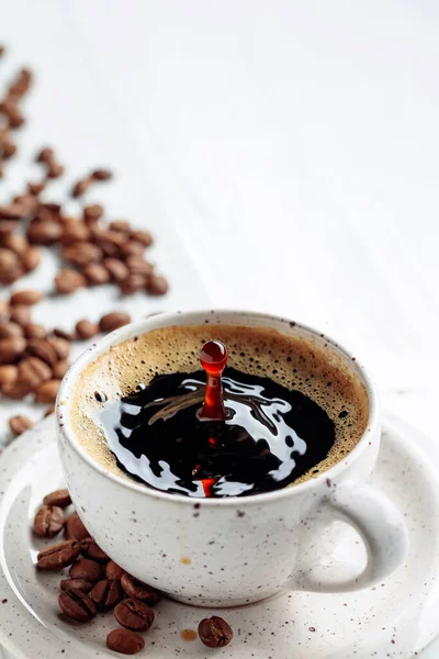 Schwarzer Kaffee Und Kaffeebohnen Auf Einem Weißen Holztisch Ein Tropfen — Stockfoto