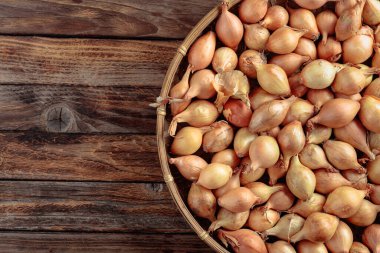 Eski ahşap bir masada soğan. Yukarıdan görüntüle, boşluğu kopyala.