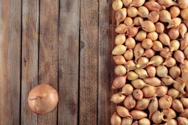 Eski ahşap bir masada soğan. Yukarıdan görüntüle, boşluğu kopyala.