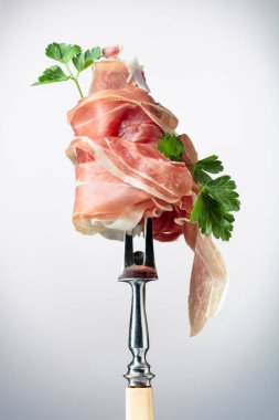 Çatalla maydanozlu ince dilimlenmiş jambon. Geleneksel İtalyan mutfağı.