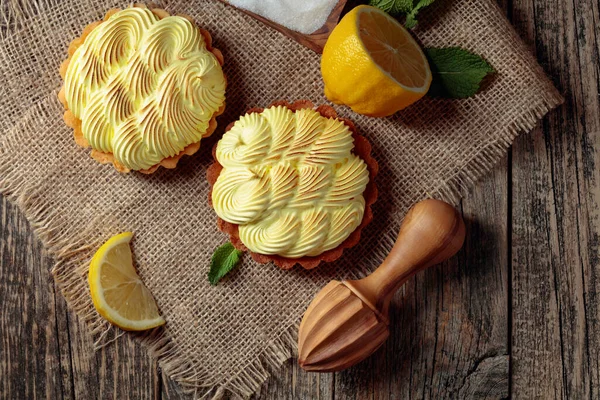 Eski ahşap bir masada limon kremalı ve naneli tart. Üst görünüm.