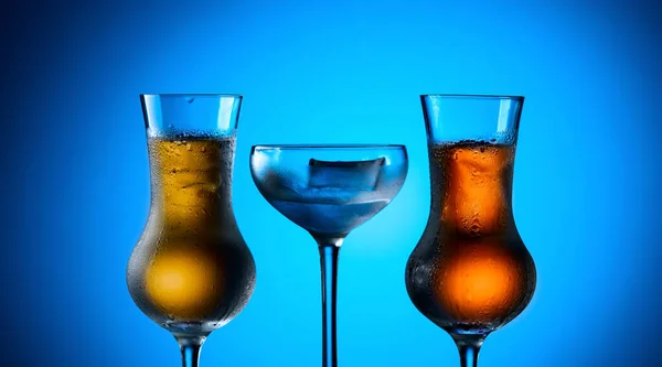Крепкие Алкогольные Напитки Плотных Стаканах Льдом Синем Фоне — стоковое фото