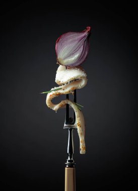 Çatalda tuzlanmış baharatlı domuz yağı. Siyah arka planda biberiyeli ve soğanlı domuz yağı. Geleneksel Ukrayna mutfağı.