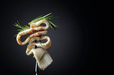 Çatalda tuzlanmış baharatlı domuz yağı dilimleri. Siyah arka planda biberiyeli domuz yağı. Geleneksel Ukrayna mutfağı. Boşluğu kopyala.