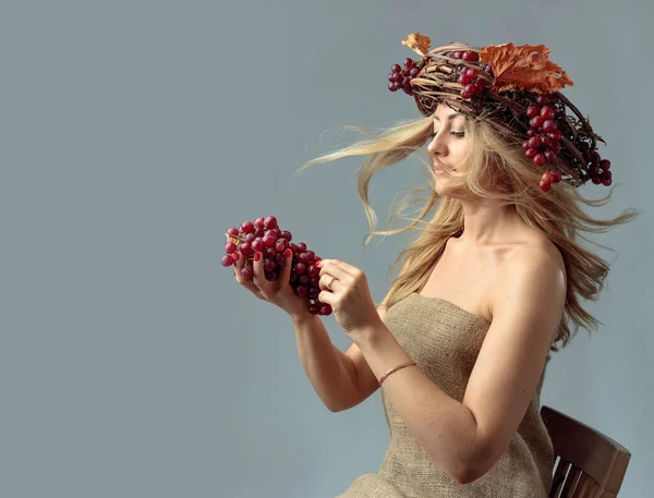 一个美丽的高加索金发姑娘的画像 她的头发在风中飘扬 在藤蔓 葡萄和干枯的树叶的花圈里 一个金发仙女的羞怯形象 — 图库照片