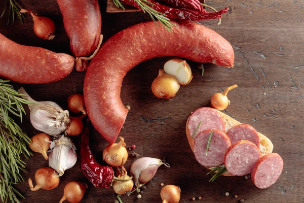 Salamlı sandviç istiyorum. Ekmek, biberiye, soğan, sarımsak ve biberli eski ahşap bir masa sosisinde. Üst görünüm.