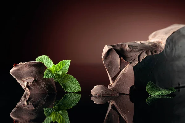 Grande Pezzo Cioccolato Fondente Amaro Con Menta Sfondo Nero Riflettente — Foto Stock