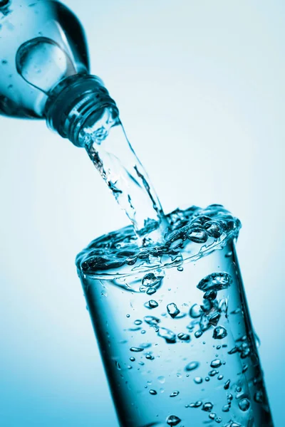 Pouring Water Plastic Bottle Glass Blue Background Copy Space — Stock Photo, Image