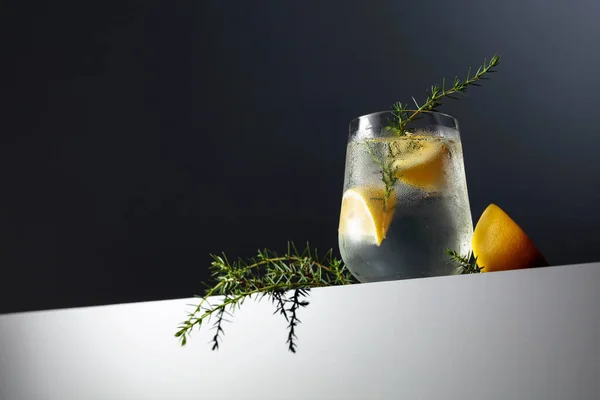 レモン ジュニパーブランチ 暗い反射背景に氷とアルコール飲料 ジン強壮カクテル コピースペース レモン入りのアイスカクテル — ストック写真