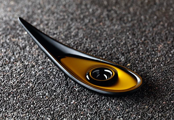 ごま油と生黒ゴマ 小さな黒い皿の中の油の落下 — ストック写真