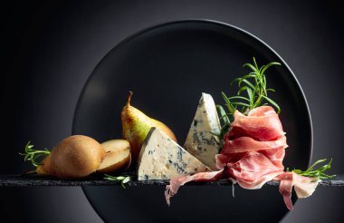 Geleneksel Akdeniz atıştırmalıkları. Peynirli, armut ve biberiyeli jambon..
