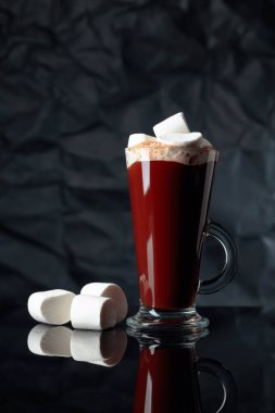 Siyah yansıtıcı arka planda kremalı sıcak çikolata. Boşluğu kopyala.