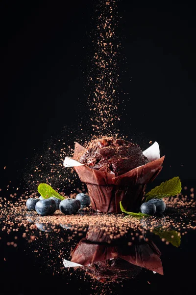 Шоколадный Кекс Посыпанный Шоколадными Крошками Черном Отражающем Фоне Кекс Ягодами — стоковое фото