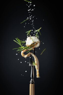 Tuz ve biberiye serpilmiş baharatlı domuz yağı dilimi. Siyah arka planda biberiyeli domuz yağı..