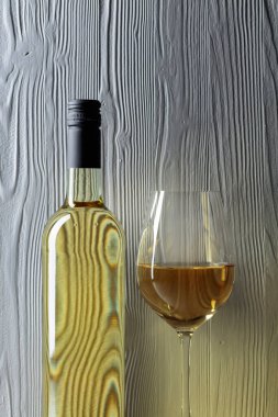 Beyaz ahşap arka planda bir şişe beyaz şarap. Boşluğu kopyala.