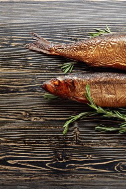 Eski ahşap bir masada tütsülenmiş ringa balığı. Baltık ülkelerinde geleneksel yiyecekler. Üst görünüm.