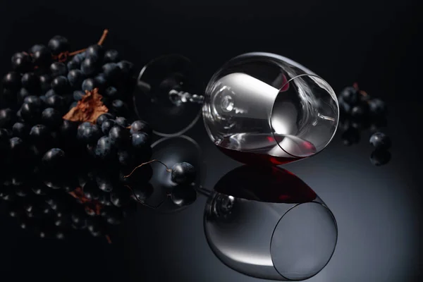 Niebieskie Winogrona Kieliszek Wina Czerwonym Winem Czarnym Tle Odblaskowym Przestrzeń — Zdjęcie stockowe