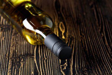 Açılmamış beyaz şarap şişesi eski ahşap bir arka planda. Boşluğu kopyala.