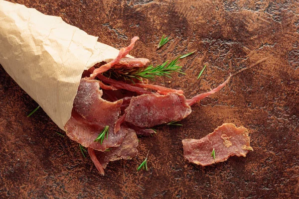 Slices Spicy Dry Cured Meat Rosemary Paper Bag Old Brown — Stock Photo, Image