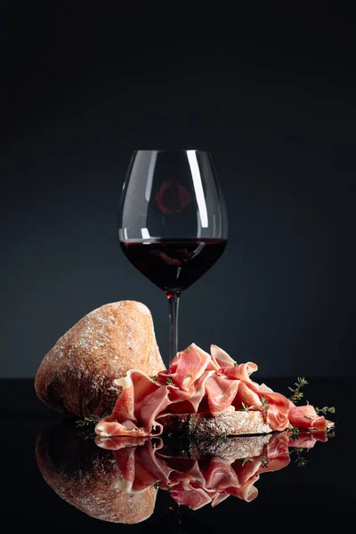 黒の反射的な背景にCiabatta 赤ワインとタイムとProsciutto — ストック写真